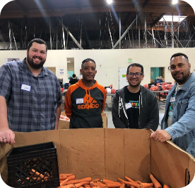 BTU Volunteers smile next to food they helped donate
