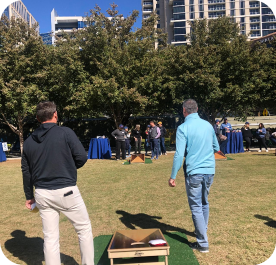 BTU employees play cornhole at a community day