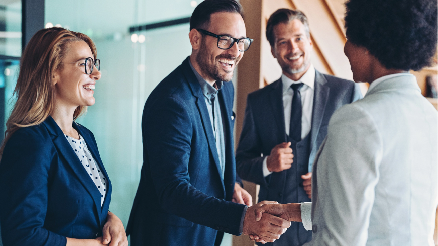 A business meeting starts with a client shaking an agent's hand